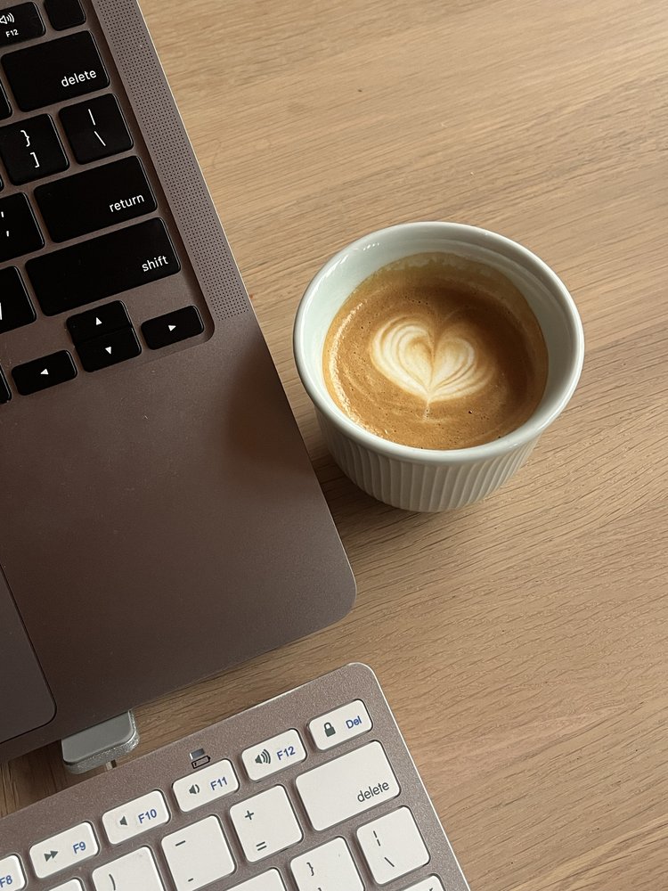 Le bureau de Delphine Da Costa : ordinateur et café