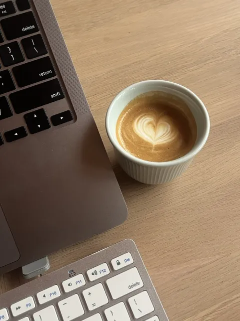 Le bureau de Delphine Da Costa : ordinateur et café